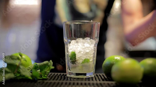Aggiunta di ghiaccio durante la preparazione cocktail mojito photo