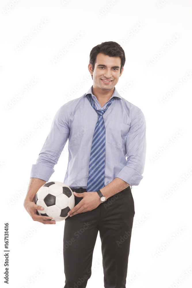 Portrait of a male executive with a football
