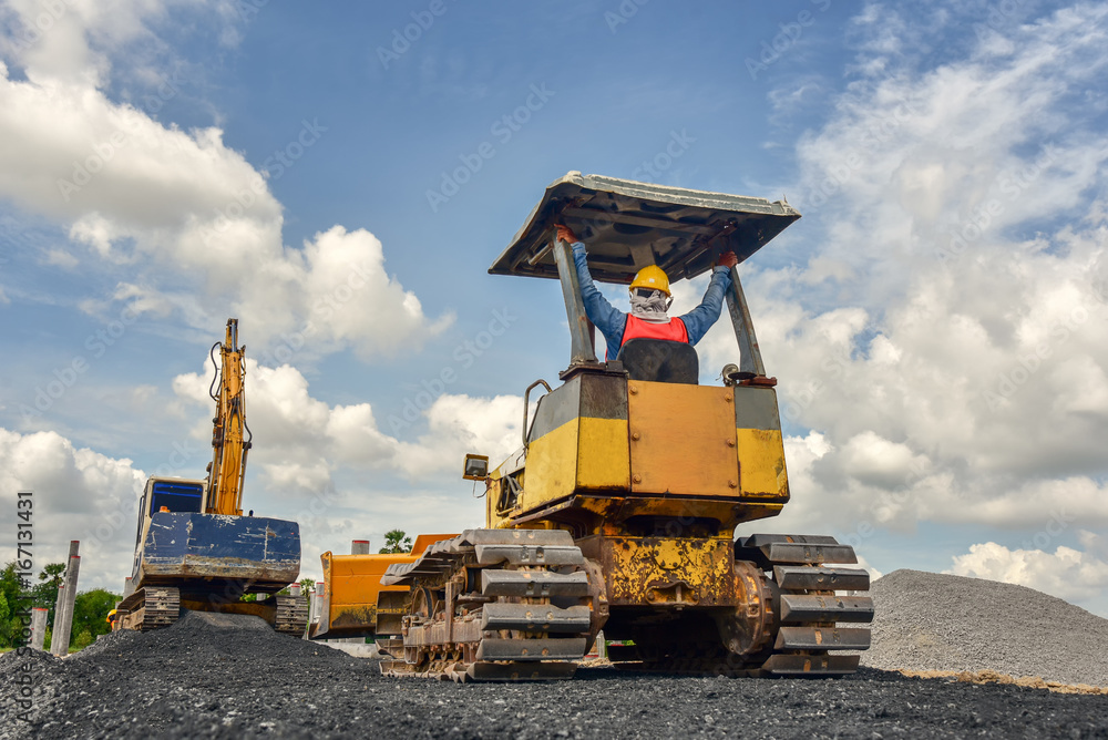 Construction worker in safety uniform driving grader tractor or ...