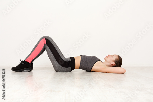 Fitness woman lay on floor at pilates training indoors