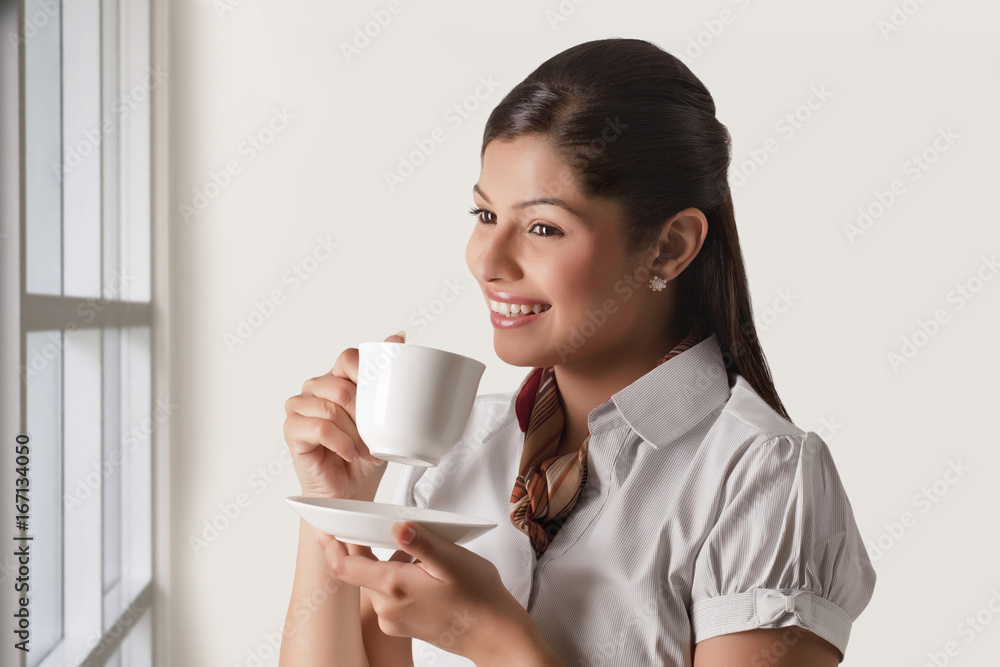 Thoughtful businesswoman having cup of tea for refreshment Thoughtful businesswoman having cup of tea for refreshment