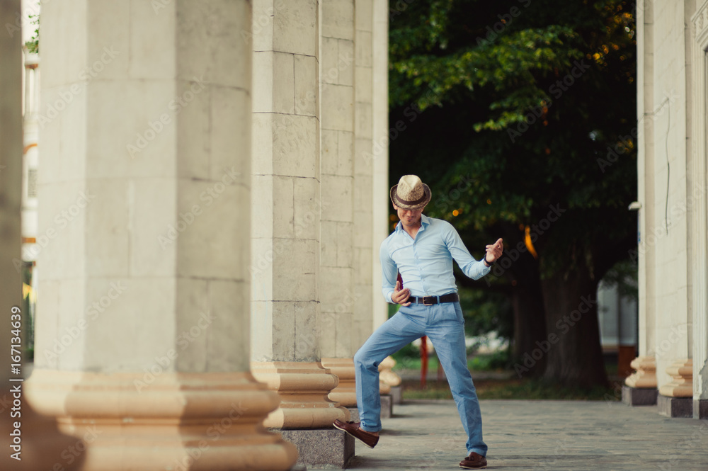 Nice man in casual clothes near the columns Nice man in casual clothes near the columns