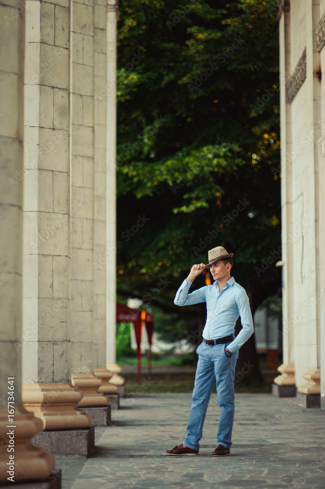 Nice man in casual clothes near the columns Nice man in casual clothes near the columns