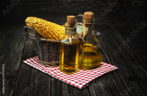 Ear of corn and bottles with corn oil photo