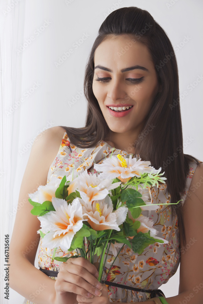 Surprise young Indian woman holding bunch of flowers at home Surprise young Indian woman holding bunch of flowers at home