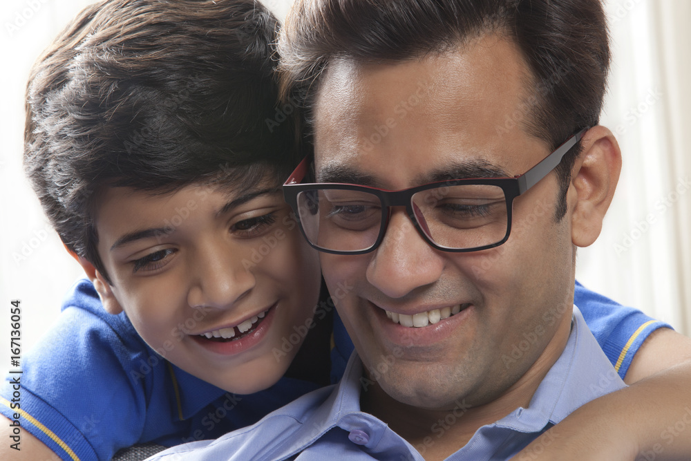 Obraz premium Close up of Smiling father and son looks from behind