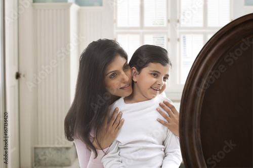 Mother and daughter smiling and looking at mirror