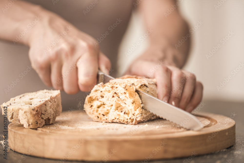 fresh bread in hands closeup on old wooden background