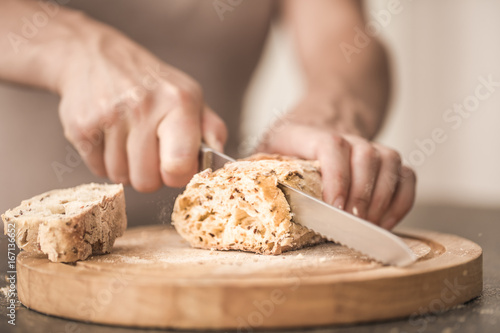 fresh bread in hands closeup on old wooden background