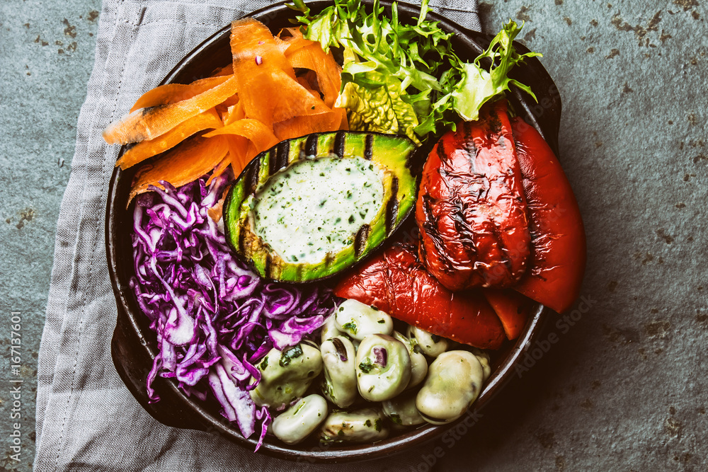 Budha bowl. Raw vegetables with beans, grilled avocado and bell pepper on slate background. Top view Budha bowl. Raw vegetables with beans, grilled avocado and bell pepper on slate background. Top view