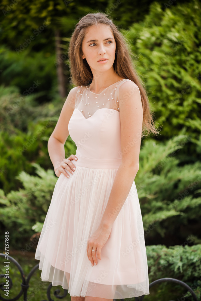 Young beautiful woman in a light summer dress