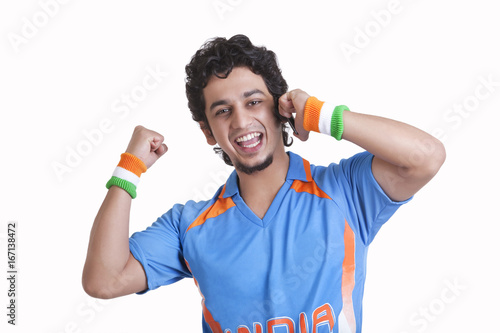 Photography Portrait of happy young man in jersey cheering with clenched fist while answerin