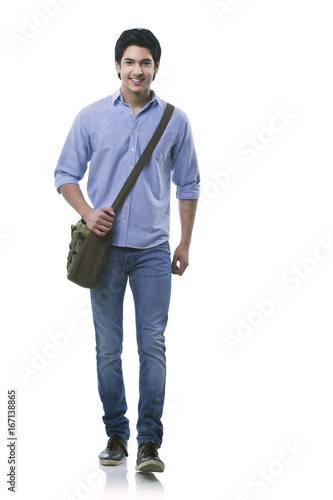 Young man walking over white background 