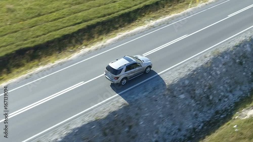 aerial view of a luxury car driving on country road
