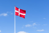 The danish flag in red and white waving in the wind