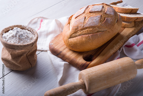 Freshly baked bread on wooden cutting board, Slice bread, wheat flour and cutting knife