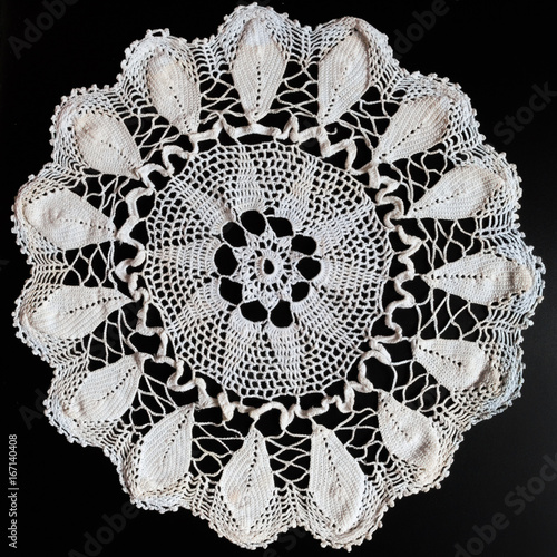 Old napkin embroidery of white thread handmade on a dark background in vintage retro antique style