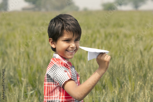 Little boy holding a paper aeroplane 