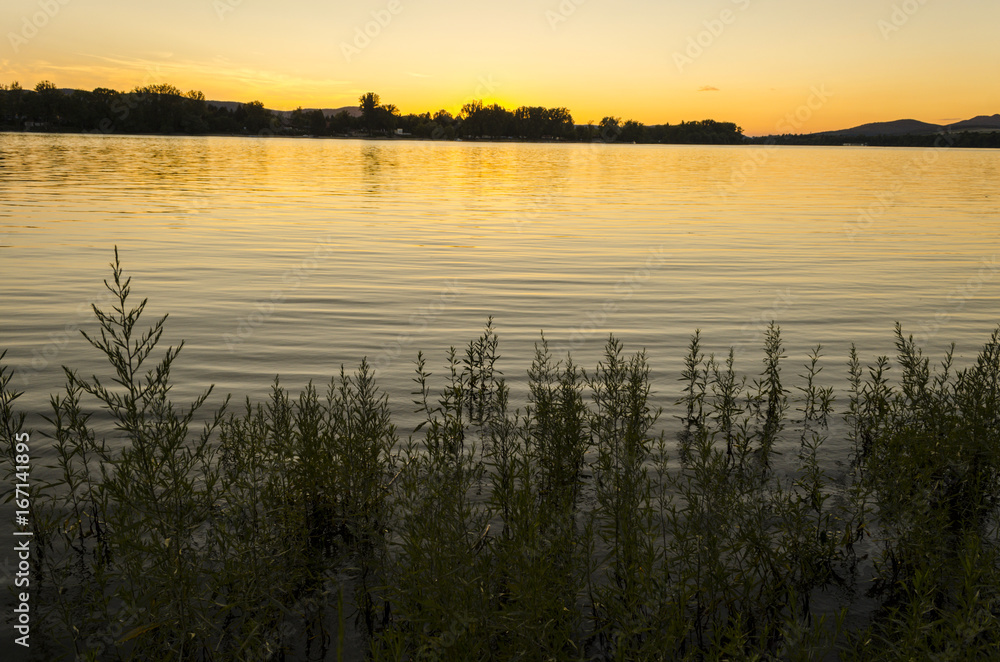 sunset, river view in summer. Colorful landscape summer sunset on the river bank. Sun rays and reflections on water sunset, river view in summer. Colorful landscape summer sunset on the river bank. Sun rays and reflections on water