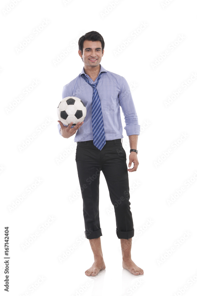 Portrait of a male executive with a football