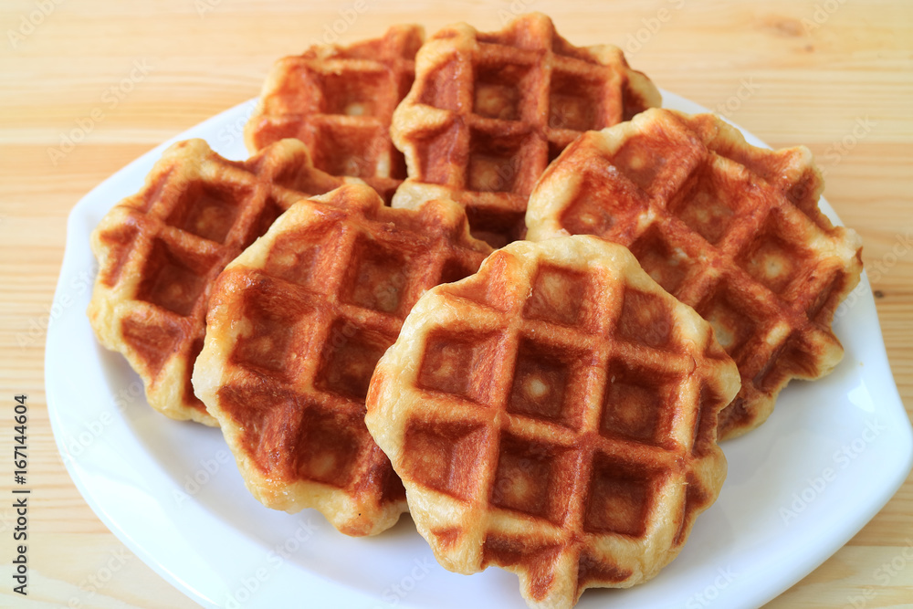 Delectable Belgian Waffles on White Plate Served on Wooden Table Delectable Belgian Waffles on White Plate Served on Wooden Table