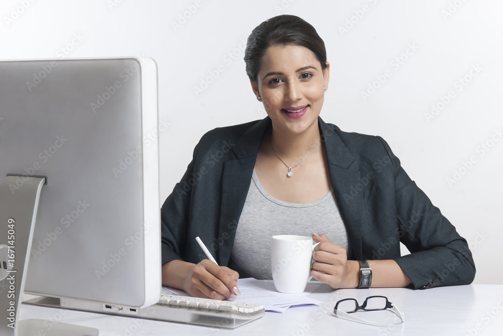 Portrait of confident businesswoman working at desk over white background Portrait of confident businesswoman working at desk over white background