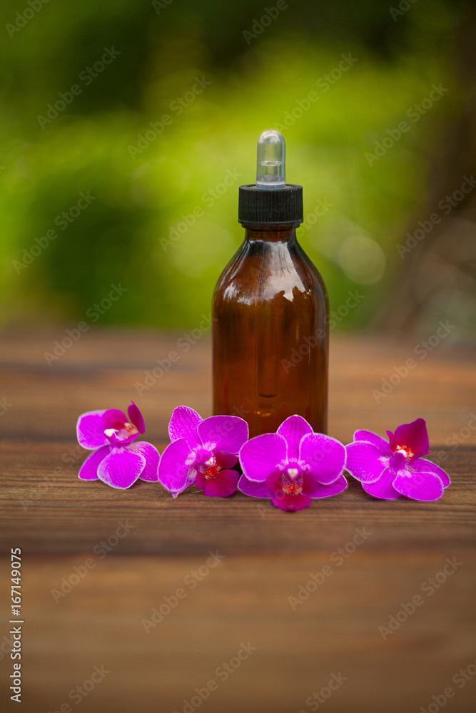 Essence of orchid flowers on table in beautiful glass jar Essence of orchid flowers on table in beautiful glass jar