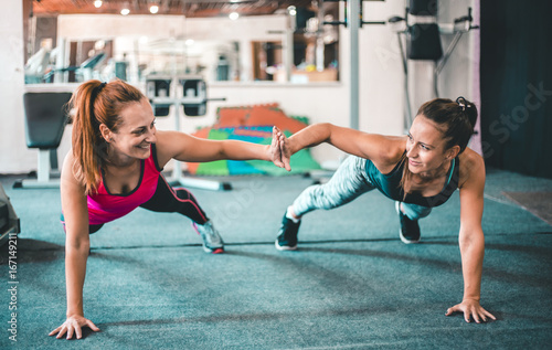 Quadro su tela Two female friends exercising together in the gym