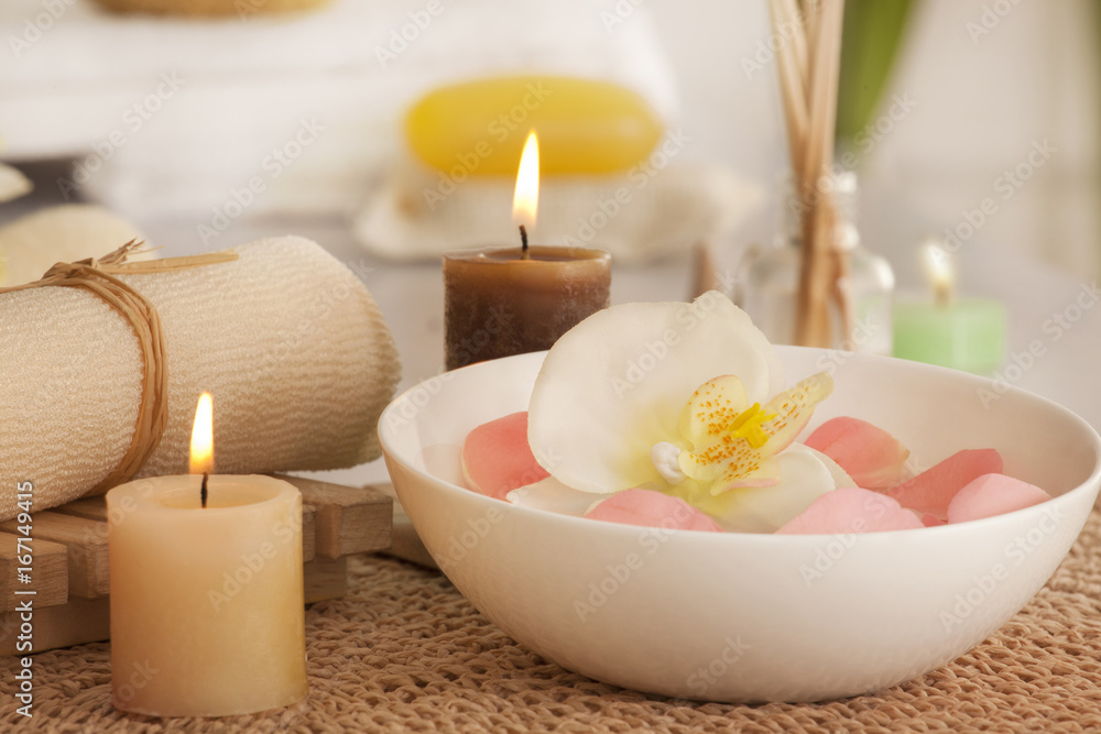 Flowers in a bowl with candles and bath scrub 