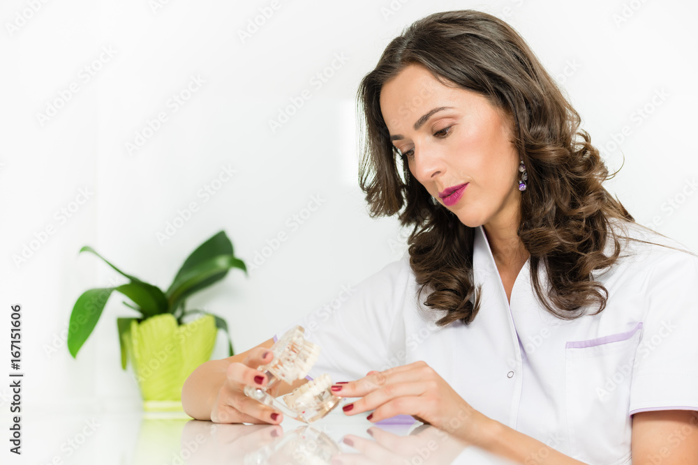Female dentist looking at dental implants on the glass table.Shallow doff Female dentist looking at dental implants on the glass table.Shallow doff