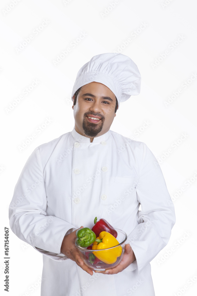Portrait of chef with bowl of capsicum Portrait of chef with bowl of capsicum