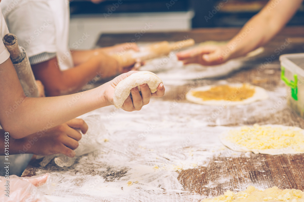 Young children make dough. Hands close up