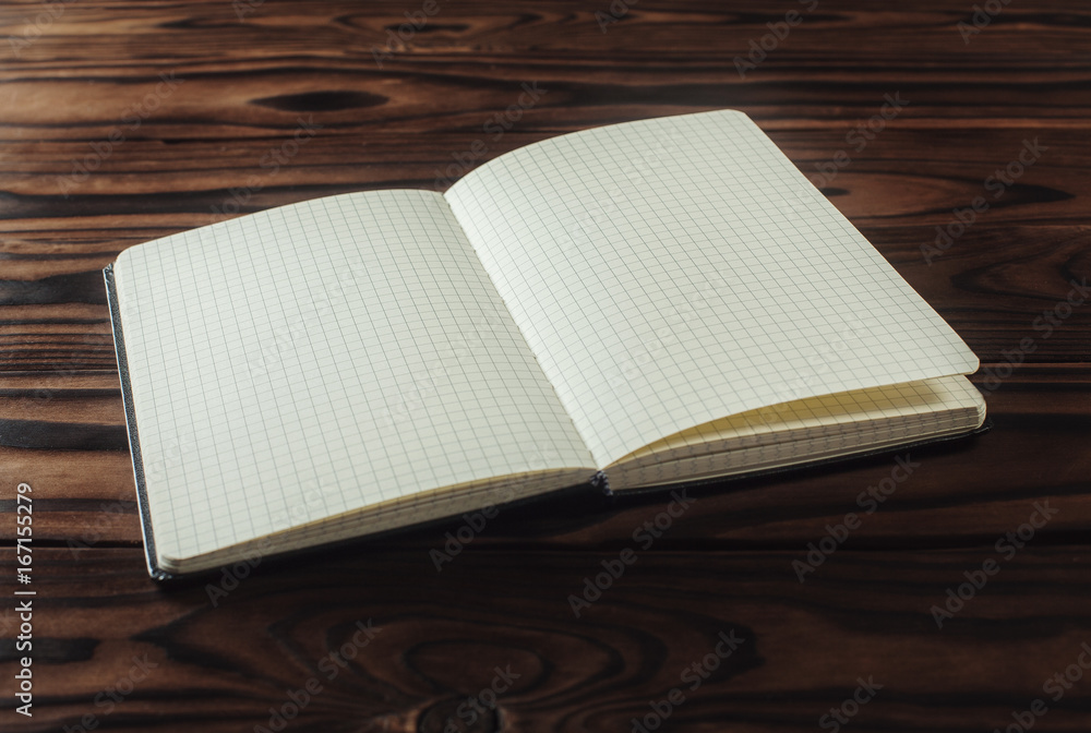 Fototapeta premium Empty notebook paper on wooden background