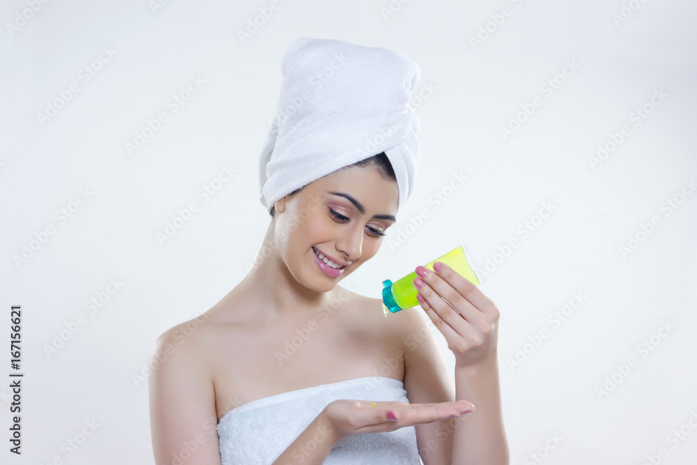 Beautiful woman pouring beauty product on palm over white background Beautiful woman pouring beauty product on palm over white background