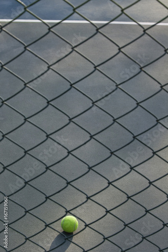Shot of tennis ball lying on ground in front of net  © IndiaPix