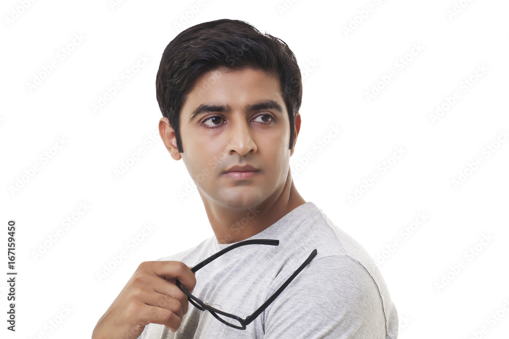 Thoughtful young man looking away over white background Thoughtful young man looking away over white background
