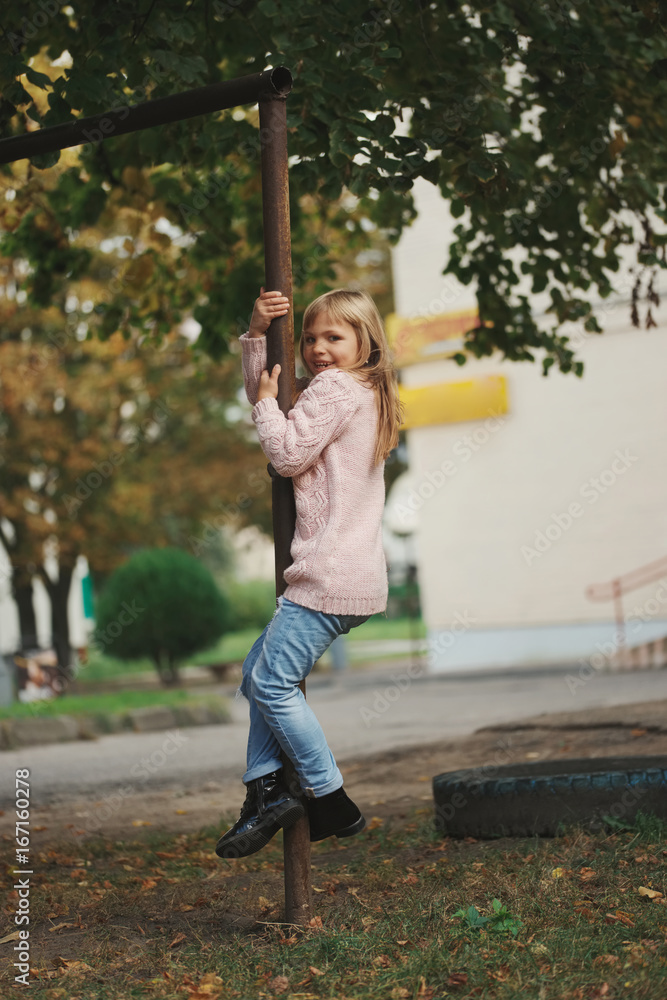 young happy girl swinging on the crossbar