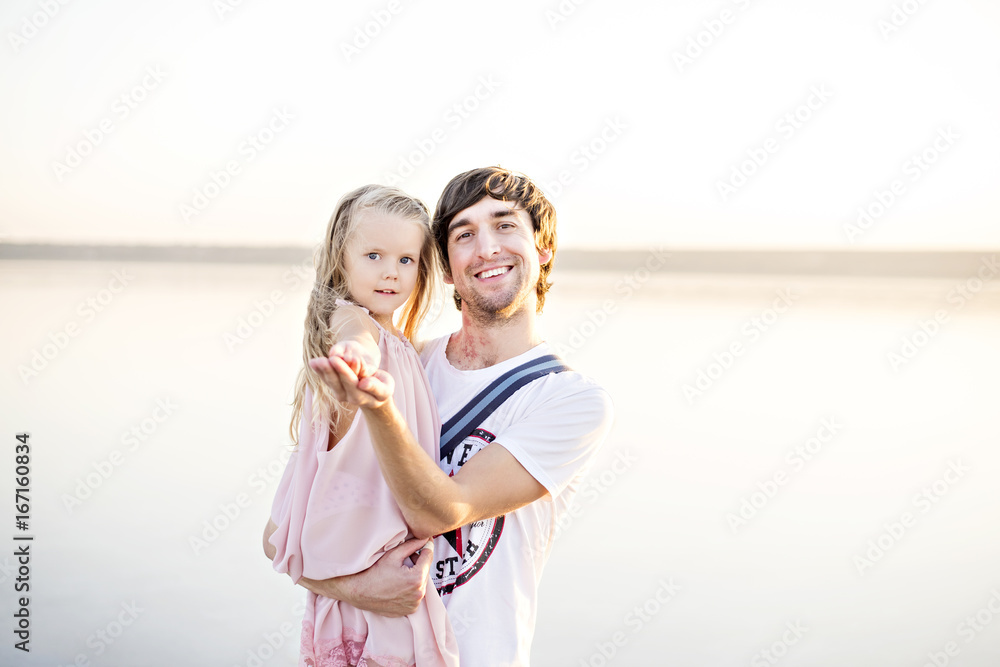 A man is holding a beautiful girl in his arms and they are smiling A man is holding a beautiful girl in his arms and they are smiling
