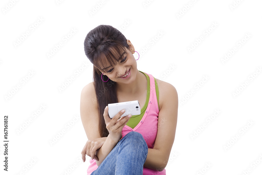 Smiling young woman reading text message over white background Smiling young woman reading text message over white background
