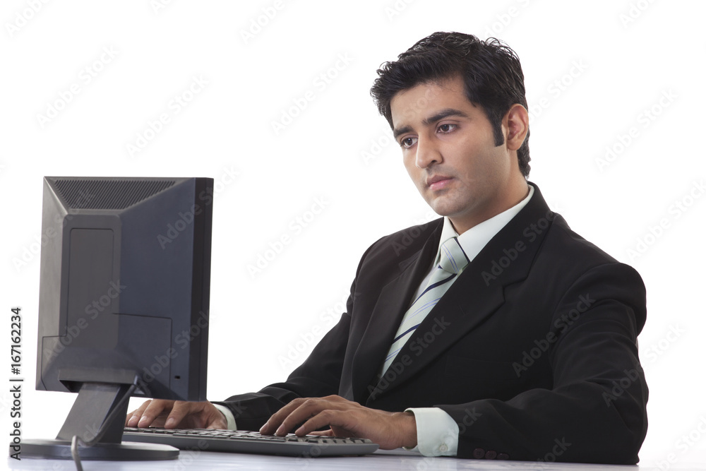 Young businessman using computer at desk Young businessman using computer at desk