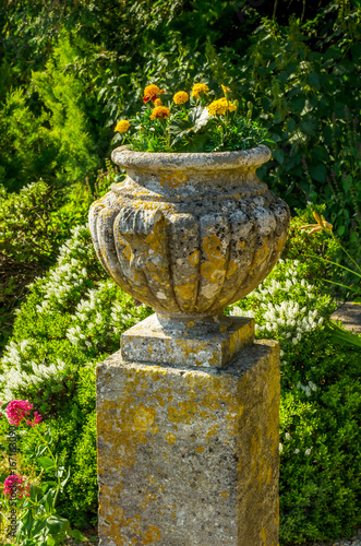 Concrete flower pots in the garden on a pedestal stylized antique, a place of rest, practical urban