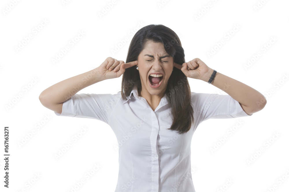Frustrated businesswoman with fingers in ears shouting over white background Frustrated businesswoman with fingers in ears shouting over white background