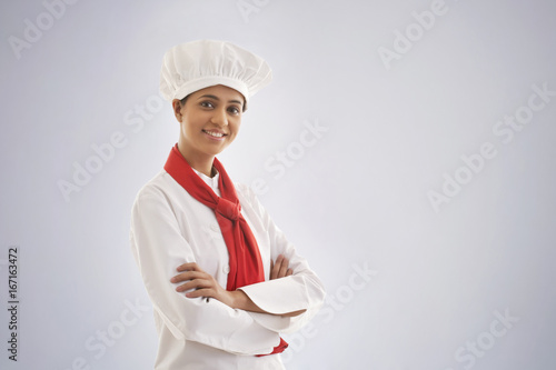 Obraz na plátně Portrait of a confident female chef isolated over gray background