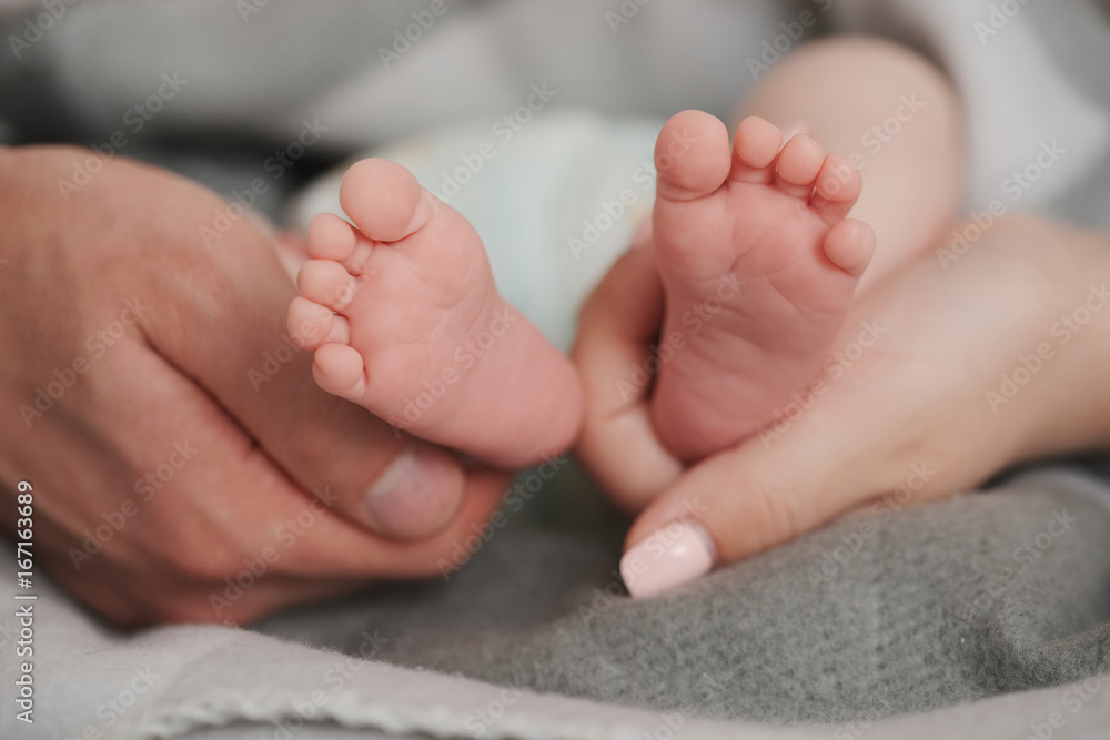 father and mother holding babies feet father and mother holding babies feet