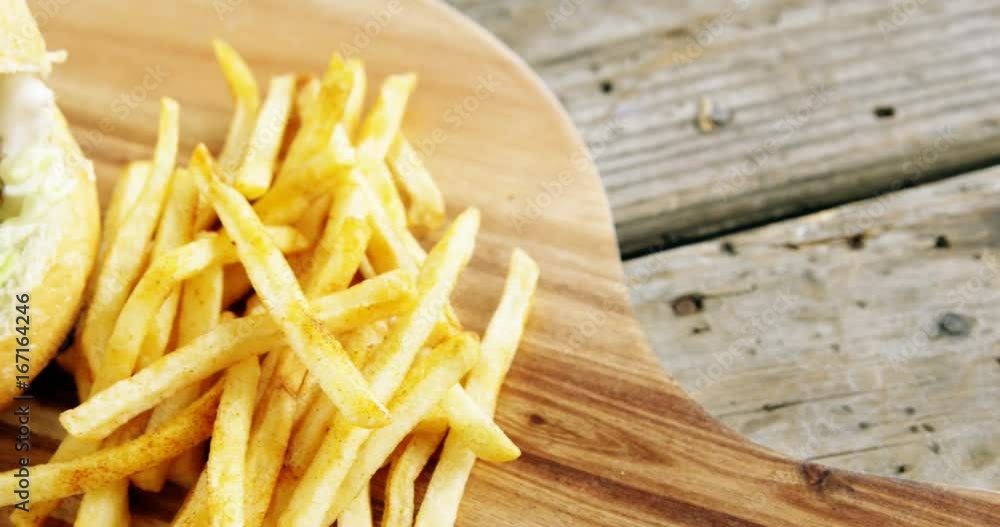 Hamburger and french fries on chopping board Hamburger and french fries on chopping board
