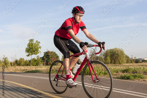 Cycling Concepts and Ideas. Male Caucasian Road Cyclist During Ride on Bike Outdoors. Completely Equipped in Professional Outfit. © danmorgan12