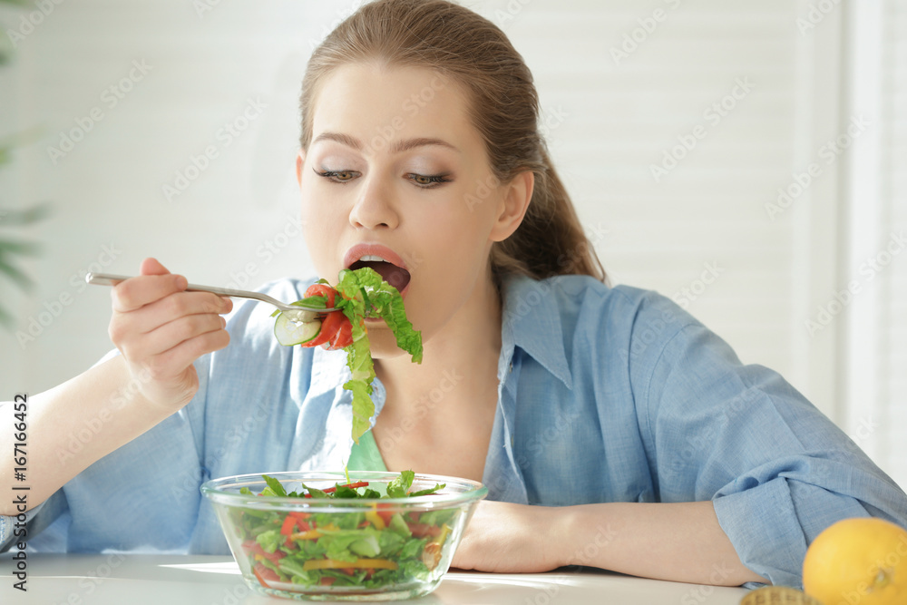 Young woman having breakfast in kitchen. Weight loss concept Young woman having breakfast in kitchen. Weight loss concept