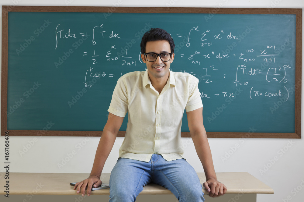 Portrait of college student sitting on a table smiling Portrait of college student sitting on a table smiling