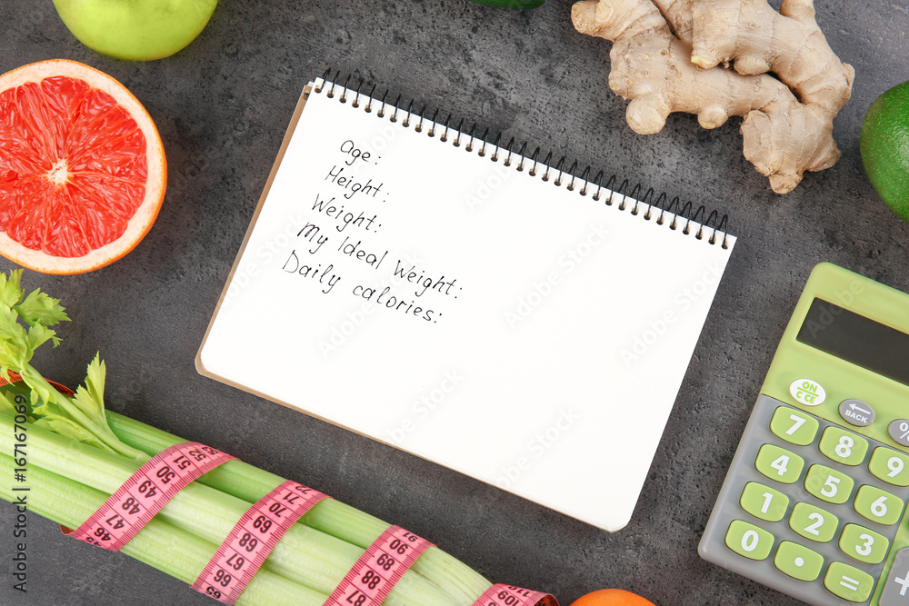 Diet concept. Notebook, calculator and groceries on gray background Diet concept. Notebook, calculator and groceries on gray background