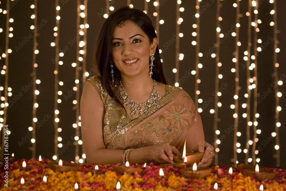Woman lighting diyas Woman lighting diyas